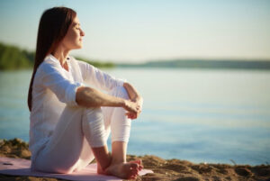 Emotional fullness invokes peace, joy and the ability to be present in the moment. The woman pictured is sitting by the water taking in the silence that brings about the joy and peace creating emotional fullness.